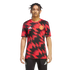 A man models a Manchester United training jersey featuring a red and black geometric pattern, paired with black Adidas joggers, against a plain white background.