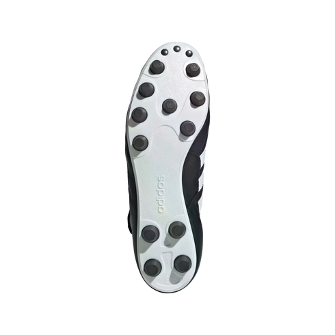 Underside of a black and white Adidas soccer cleat featuring a white soleplate with multiple black circular studs and embossed branding, set against a solid black background.
