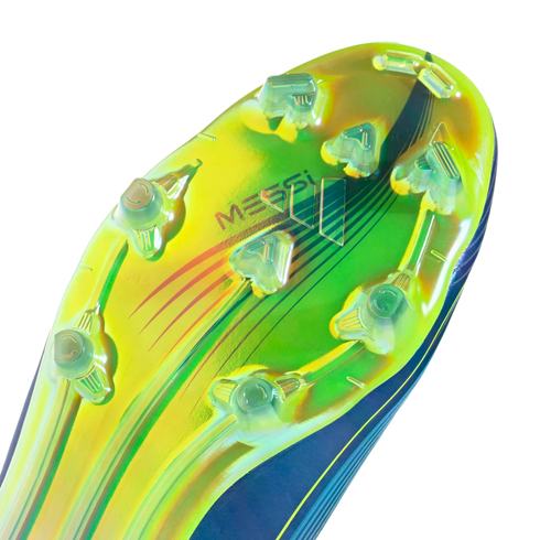 Vibrant lime green and blue iridescent soleplate of a Messi soccer boot with transparent studs and "MESSI" branding.