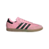 Side profile of a pink Adidas Samba sneaker with black stripes, a gum sole, and "MESSI" in gold lettering on the side.