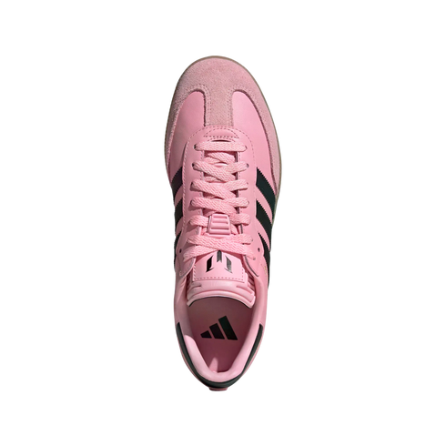 Top-down view of a pink Adidas sneaker with black stripes and pink laces, featuring the Messi "M" logo on the tongue, isolated on a white background.
