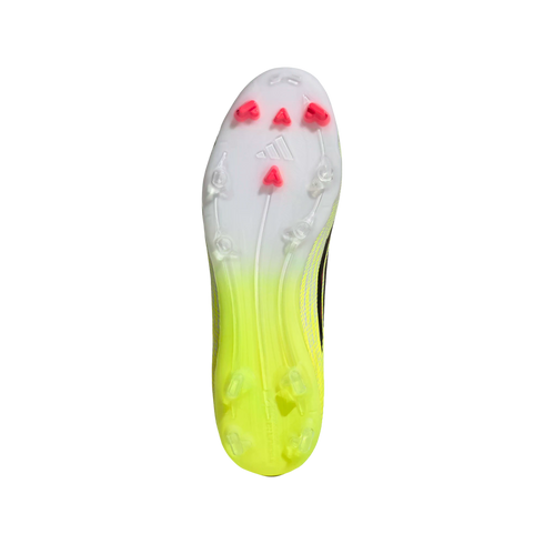 The sole of an Adidas soccer shoe with a neon yellow-to-white gradient and pink triangular studs on the forefoot.