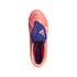 Top-down view of a coral Adidas Predator soccer cleat with a blue fold-over tongue and white stripes against a black background.