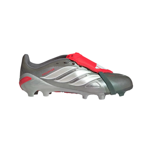 Profile of a silver Adidas Predator soccer cleat featuring white side stripes, a red fold-over tongue with an elastic strap, and grey studs, set against a solid black background.