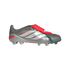 Profile of a silver Adidas Predator soccer cleat featuring white side stripes, a red fold-over tongue with an elastic strap, and grey studs, set against a solid black background.