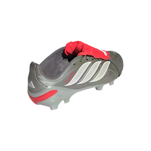 A metallic gray Adidas Predator soccer cleat with three white stripes and a red fold-over tongue, isolated on a black background.