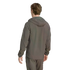 Rear view of a person in a grey hooded windbreaker and matching pants against a solid black background.