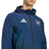 Man wearing a navy blue Adidas hooded jacket with the Arsenal football club crest and white Adidas logo, against a black background.