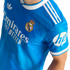 A blue Real Madrid soccer jersey with white Adidas Trefoil, Emirates, and HP logos, white shoulder stripes, and the team's crest.