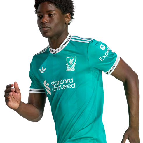 A young man in a teal Liverpool FC football jersey with white and black trim, posing in an athletic stance against a solid black background.