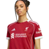 A woman wearing a red Liverpool F.C. football jersey with white trim and sponsor logos, facing forward against a black background.
