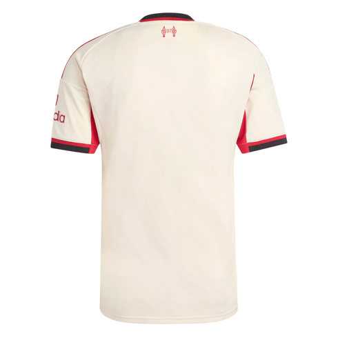 Back of a cream Liverpool FC away jersey with red and black trim. It features the red Hillsborough memorial logo below the collar and a sponsor logo on the left sleeve.