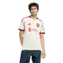 A young man wearing a white and red Adidas Liverpool F.C. soccer jersey and blue jeans, standing against a solid black background.