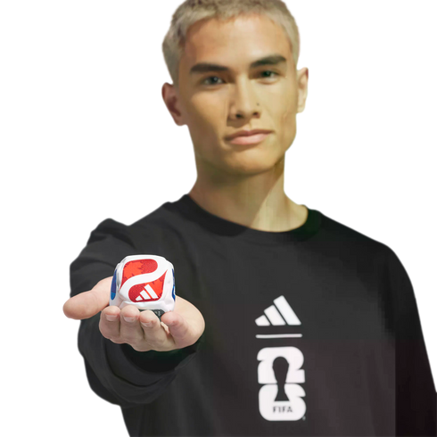 A blonde man in a black Adidas FIFA 2026 sweatshirt holds out a small white cube with red and blue branding against a black background.