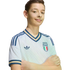 A young boy smiles with arms crossed, wearing a white Adidas Italian national soccer team jersey against a solid black background.