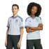 A boy and a girl posing in light blue Adidas Italy national team soccer jerseys and dark bottoms against a black background.