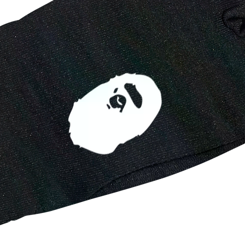 A white BAPE Ape Head logo printed on black fabric.