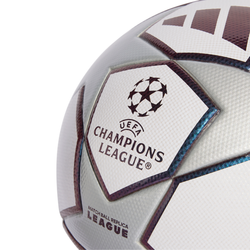 Close-up of a silver and white UEFA Champions League replica soccer ball featuring the official starball logo and textured panels.