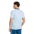 A man from behind, wearing a light-blue short-sleeved t-shirt with dark blue shoulder stripes and dark blue shorts with white side stripes, against a black background.