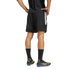 Rear view of a person wearing black Adidas athletic shorts, a black shirt, and soccer cleats against a plain white background.