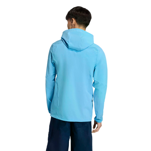 Back view of a person wearing a light blue hooded jacket and dark blue shorts against a solid black background.
