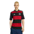 A young blonde man wears a red and black striped Adidas Germany jersey and dark blue shorts, posing against a white background.