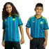 Two children smile while wearing matching teal and blue patterned Colombia national team soccer jerseys with yellow accents.