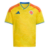 Bright yellow Colombia national football team jersey featuring a subtle butterfly wing pattern, the team crest, blue accents, and orange-red shoulder stripes.