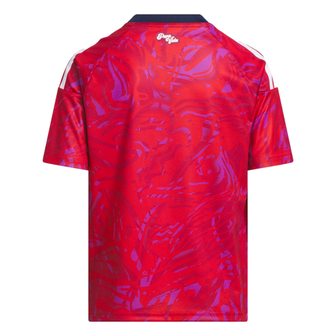 Back view of a red and purple abstract patterned jersey with white stripes on the shoulders, a navy collar, and a small 'Pura Vida' logo at the nape.