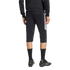 Rear view of an athlete wearing black three-quarter length soccer training pants with white side stripes and black soccer cleats against a plain background.