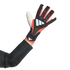 An arm wearing a black and red Adidas goalkeeper glove with white logos against a black background.