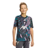 A young boy smiling in a dark Liverpool FC training jersey with pink and teal patterns and grey shorts against a black background.
