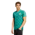 A young man wearing a green Adidas Germany soccer jersey with a white geometric pattern, standing against a white background.