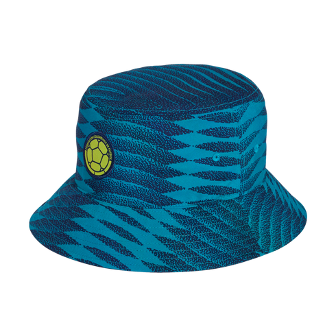 A bucket hat with a teal and navy blue wavy pattern, featuring the circular yellow and green logo of the Federación Colombiana de Fútbol.