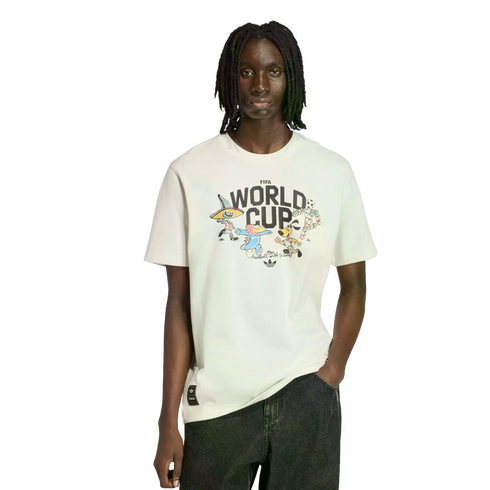 A person with dreadlocks wears a white Adidas FIFA World Cup t-shirt featuring mascot graphics and dark jeans, shown against a solid black background.