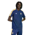 A man wearing a navy blue Adidas Real Madrid t-shirt and matching track pants with yellow and white stripes against a solid black background.