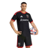 A D.C. United soccer player posing in the team's black and red home kit, holding a soccer ball against a black background.