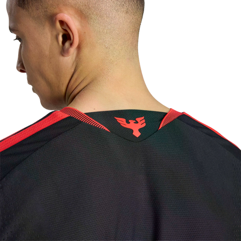 Close-up of a man's neck and the back of a black athletic jersey with a red phoenix logo on the collar and red shoulder stripes.