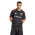 A man wearing a black D.C. United soccer jersey with red shoulder stripes and a white Guidehouse sponsor logo, posing against a solid black background.