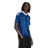 A man models a blue Adidas Greece national team jersey with white shoulder stripes and a white V-neck collar against a solid black background.