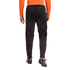 Rear view of a person wearing black Climacool athletic pants and soccer cleats, wearing an orange long-sleeved top against a black background.