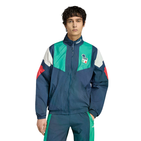 A man in a blue, green, and white adidas Italy tracksuit with the national team crest, standing against a plain white background.