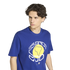 A young man with dark wavy hair wears a blue t-shirt featuring a large graphic with a yellow circle, a map of South America, and the text "25 ANOS 2001" against a white background.