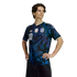 Man wearing a black Argentina football jersey with blue swirling patterns and the number 10, standing with hands on hips against a black background.