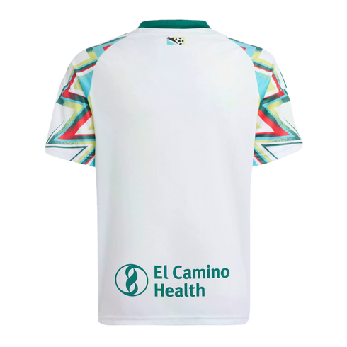 Back view of a white soccer jersey with colorful geometric patterned sleeves, a teal collar, and "El Camino Health" printed in teal at the bottom.