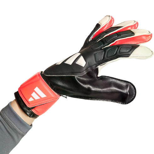 A hand wearing a black, red, and white goalkeeper glove with a red wrist strap, shown against a white background.
