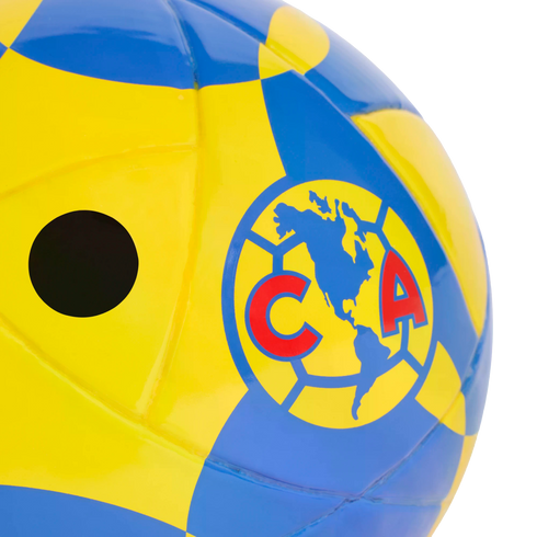 Close-up of a yellow and blue soccer ball featuring the Club América logo and an inflation valve hole.