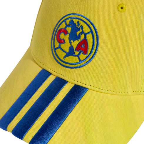 Yellow baseball cap featuring an embroidered Club América logo on the crown and three blue stripes on the brim.