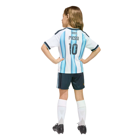 Back view of a child in a light blue and white striped Messi #10 soccer jersey, dark shorts, and white socks, standing against a black background.