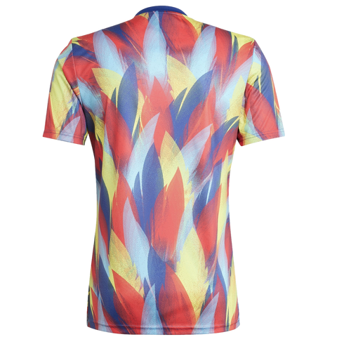 Back view of a short-sleeved t-shirt featuring a vibrant abstract pattern of overlapping red, yellow, and blue leaf-like shapes.